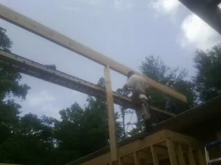 Carpenter setting a ridge beam over a new addition frame — Ice Dam Removal by Roofing Brothers in Mooresville