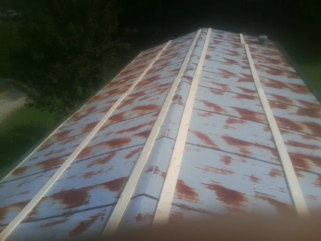 Rusted metal roof panels with new wood purlins before replacement — Storm Damage Roof Repair in Mooresville by Roofing Brothers
